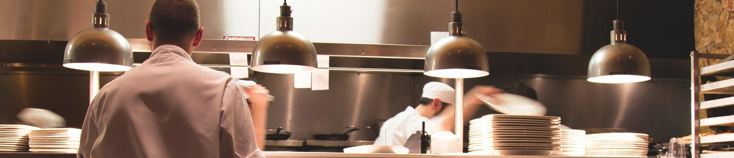 Foto della cucina di un ristorante col personale al lavoro